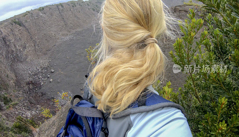 女人沿着火山边缘徒步旅行