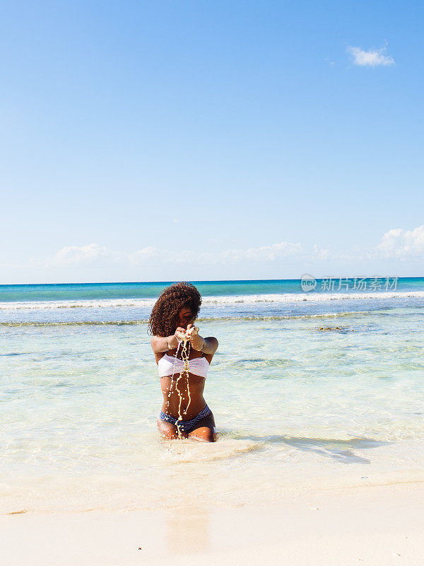 卷毛女人在海边玩沙子
