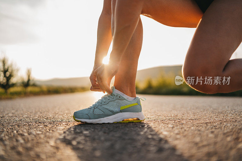 女跑步者系鞋带准备慢跑