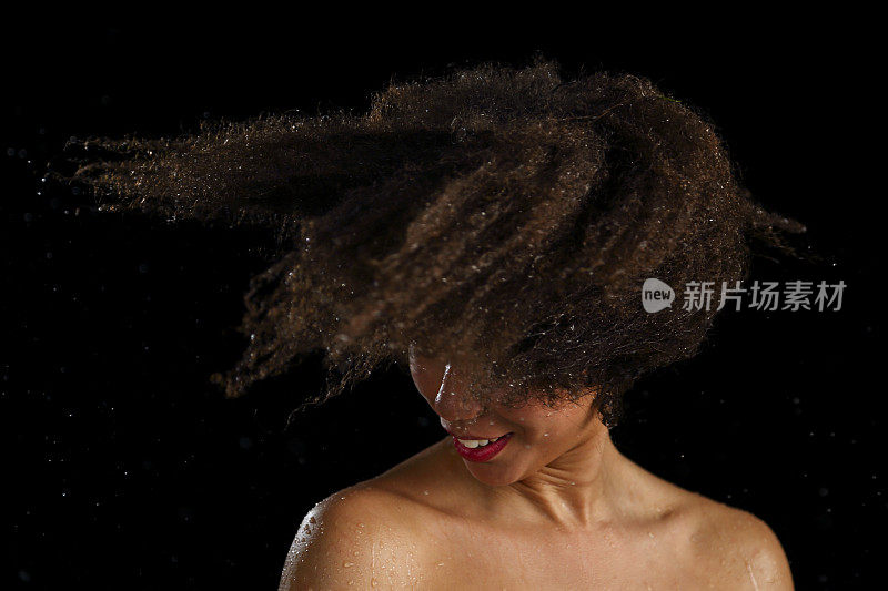一位非裔美国妇女摇晃着她湿漉漉的头发