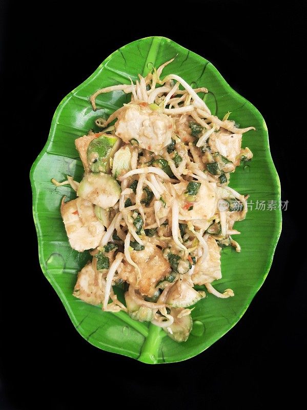 印度尼西亚生蔬菜沙拉(印度尼西亚生蔬菜沙拉，加花生酱)放在有叶状图案的盘子上
