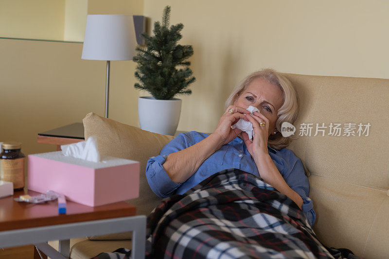 生病的老女人在床上与季节性过敏和温度。