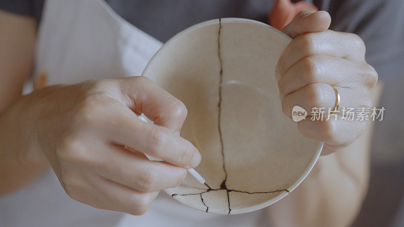 修理破陶器的女人。Kintsugi。