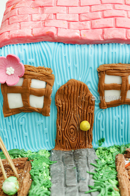 完整的框架形象自制蛋糕设计为小屋和花园，有提高的蔬菜床，黄油糖霜草与巧克力片和饼干屑土壤菜地，方糖糖霜南瓜和道路