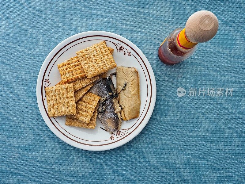 沙丁鱼和编织小麦饼干作为一种健康营养小吃与桌子，椅子，辣椒酱，和用餐区背景