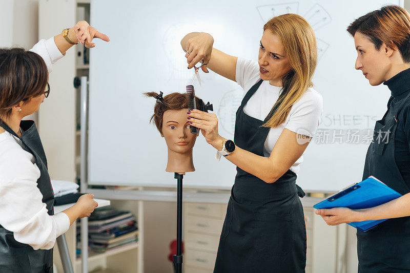专业美发师在课程中教成人学生如何使用理发剪刀
