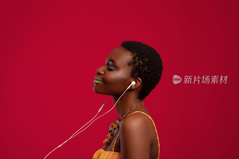 快乐的美国黑人女士戴着耳机听音乐