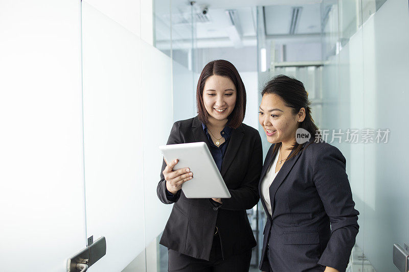 两个女人在办公室走廊里聊天