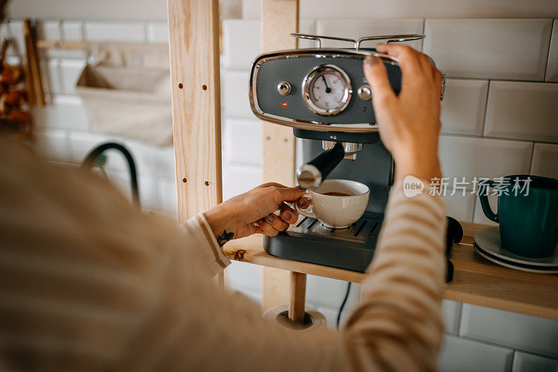 在厨房用机器煮咖啡的女人