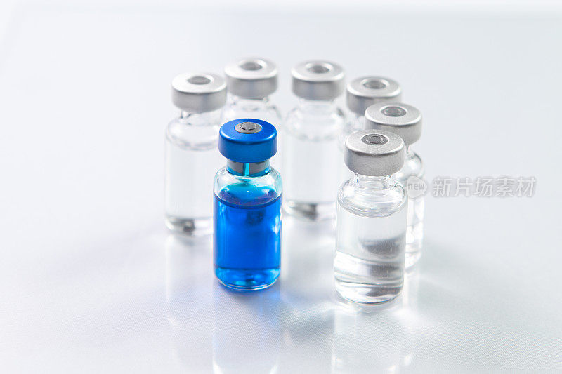 更好的药物蓝色的药物装在玻璃小瓶里，周围环绕着不同的药物小瓶