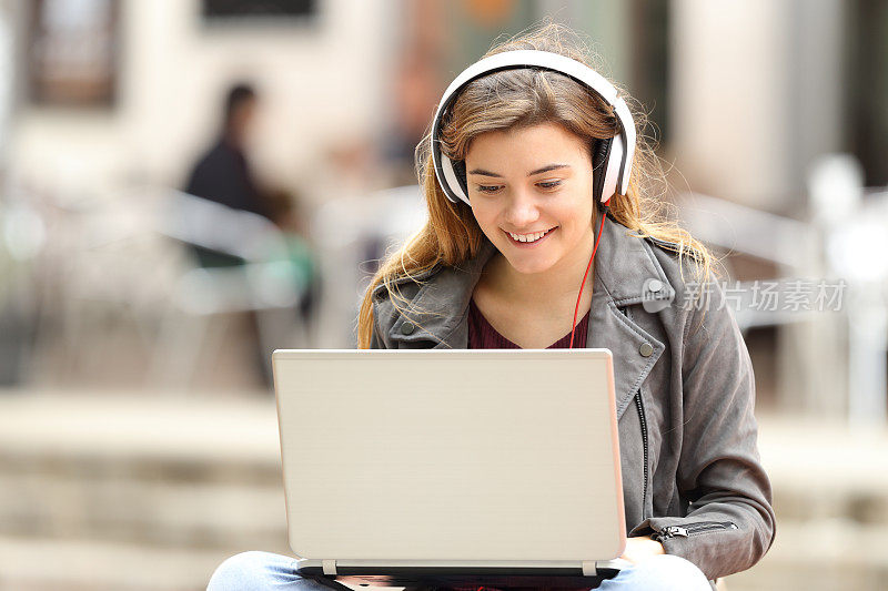 女孩在电脑上听音乐，下载音乐
