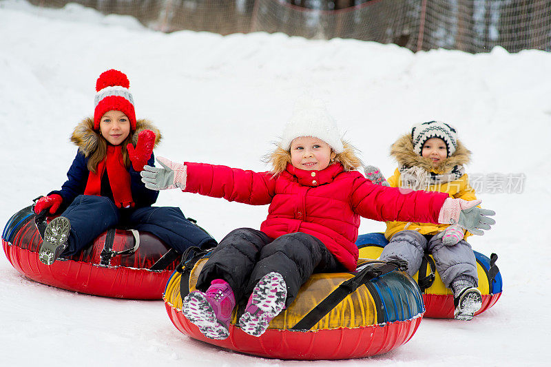 孩子们在冬天乘坐雪道下山