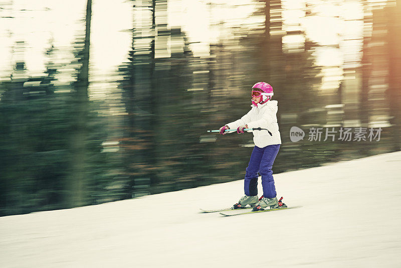 小女孩在滑雪课上练习滑雪