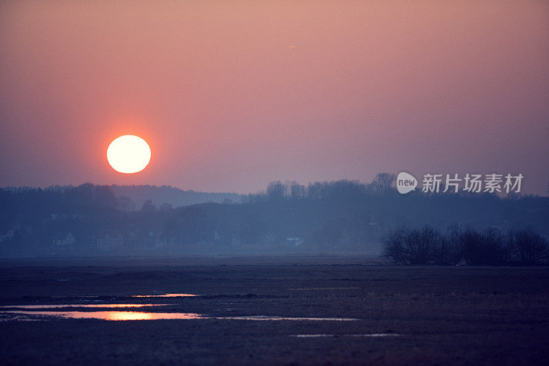 草地上美丽的橙色夕阳