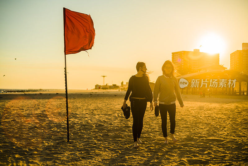 两个十岁的女孩在布鲁克林的科尼岛海滩散步