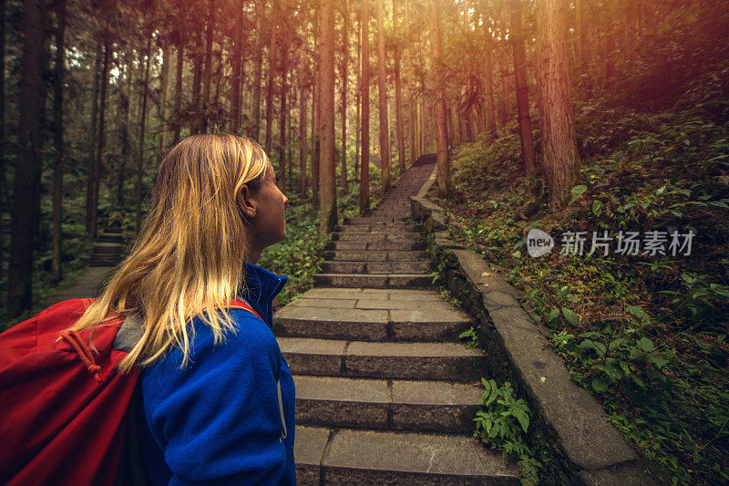 快乐的年轻女子徒步在森林，中国