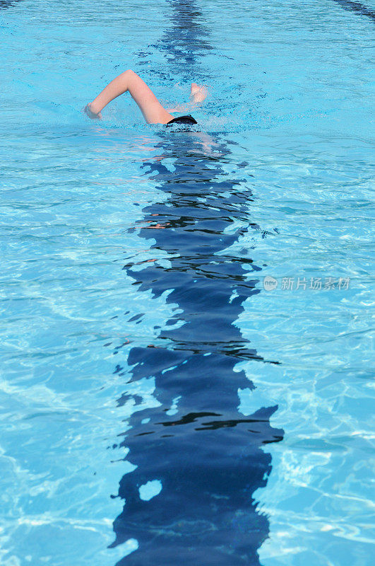 年轻女性儿童体育运动员在游泳池自由式游泳