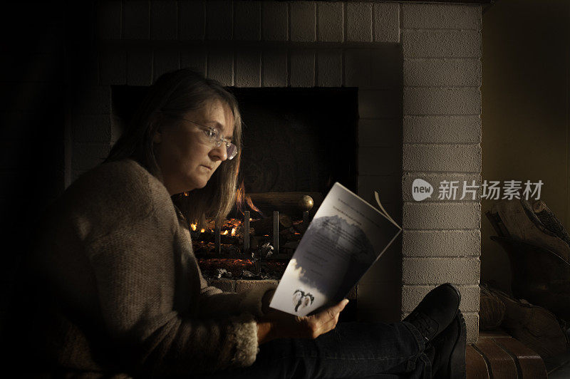 在火边看书的女人