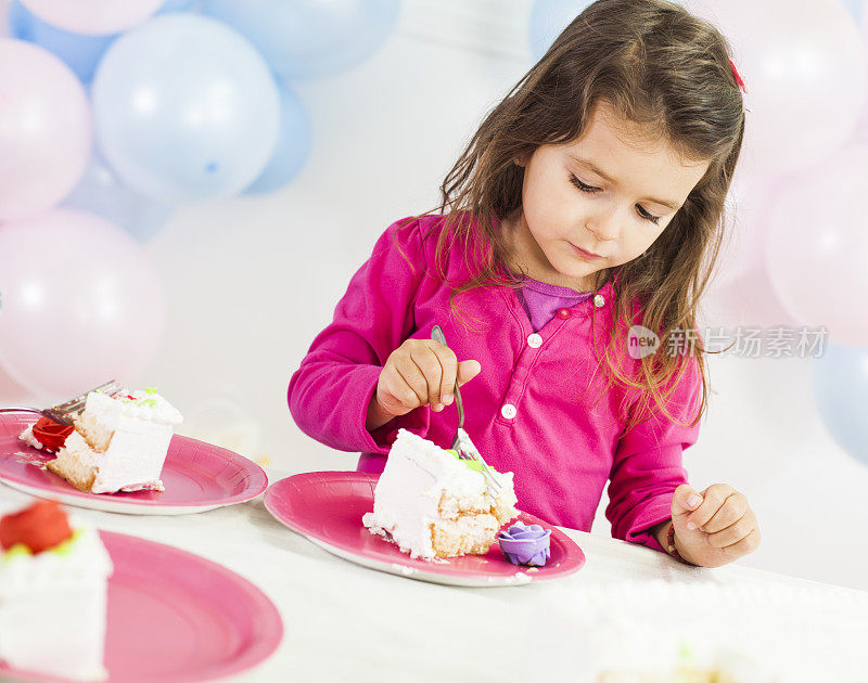 小女孩在生日聚会上吃蛋糕