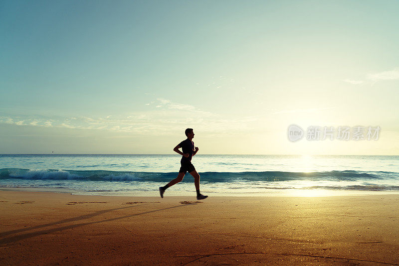 日落时分，在热带海滩上跑步的人