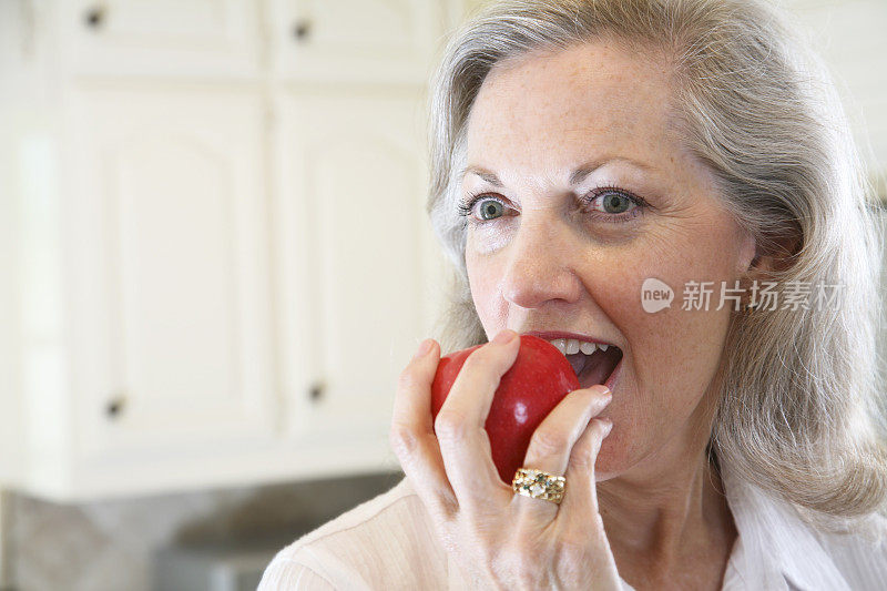 《漂亮女人》在厨房里咬苹果