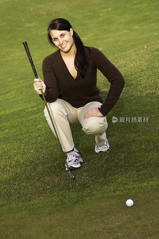 女子跪握高尔夫球杆