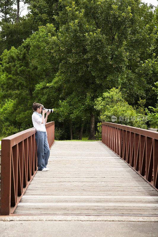 摄影师在公园外的桥上拍摄。