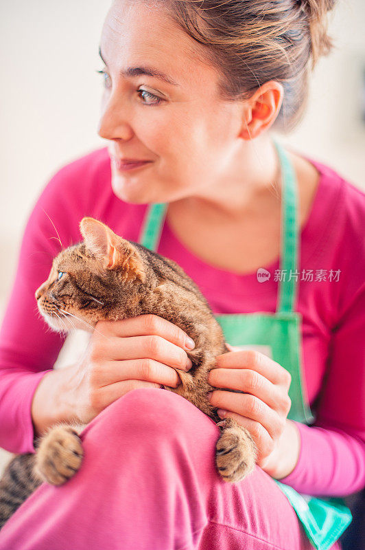 白人妇女在家里爱抚猫