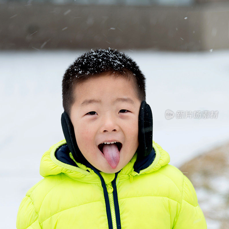 一个亚洲男孩在雪地里玩