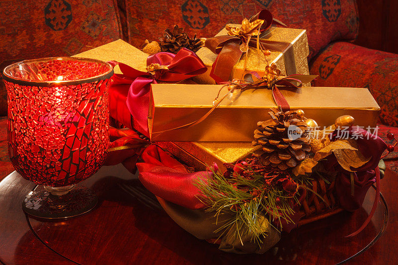 圣诞礼物，金盒子，丝带，松果和蜡烛