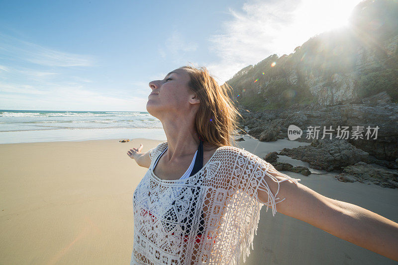 一位年轻女子在日落时分的海滩上休息