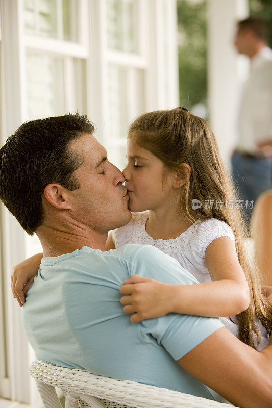 父亲在家庭团聚时亲吻女儿。