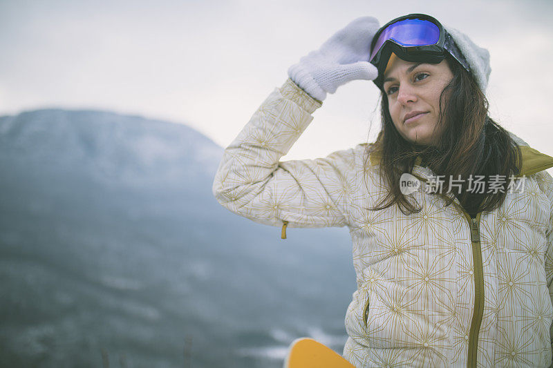 冬天穿着滑雪服的女人靠近滑雪板