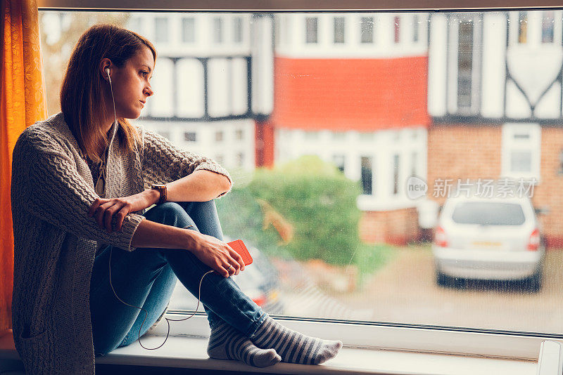 一个轻松的女人坐在窗边