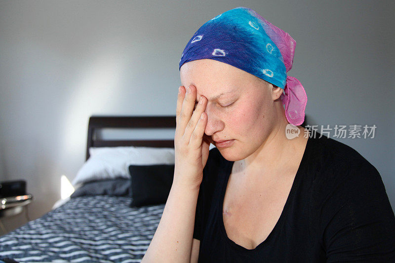 年轻的癌症患者戴着头巾手牵手面对压力和悲伤