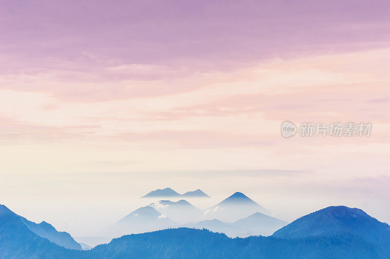 危地马拉Quetzaltenango拍摄的阿提兰湖迷雾火山上的紫色日落