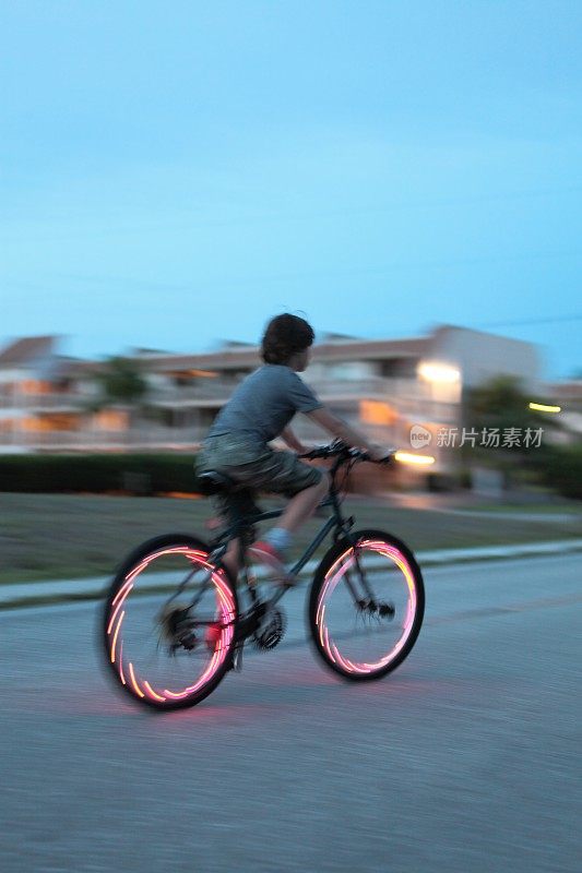 男孩骑自行车。自行车红灯。