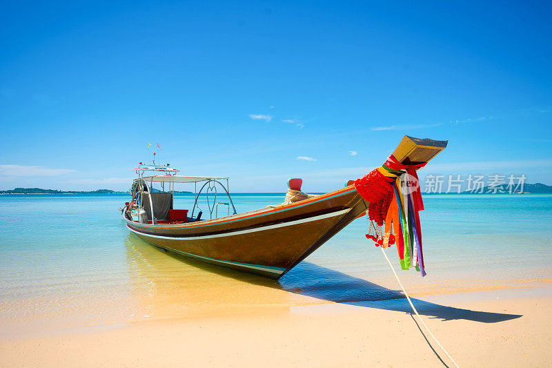 渔民长尾船停泊在海滩在阳光灿烂的日子