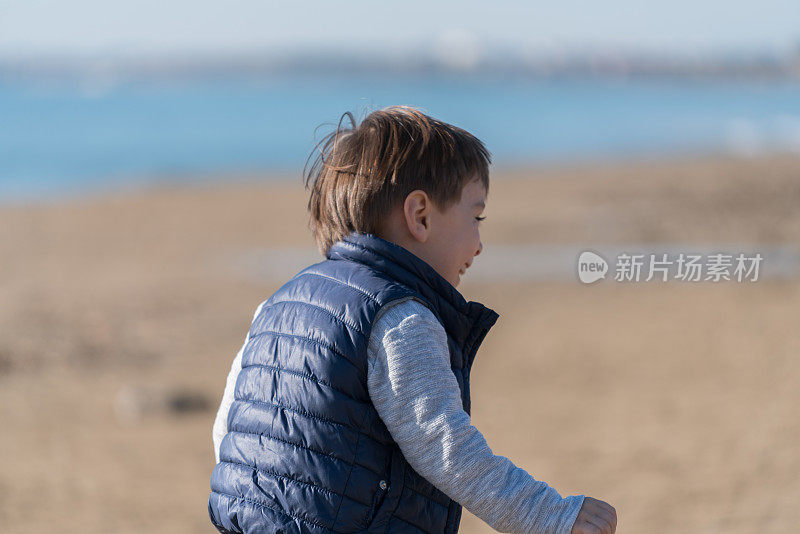 小男孩在海滩上跑步