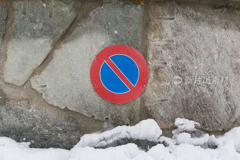 危险的雪崩警告标志坐落在冰冷的岩石与雪