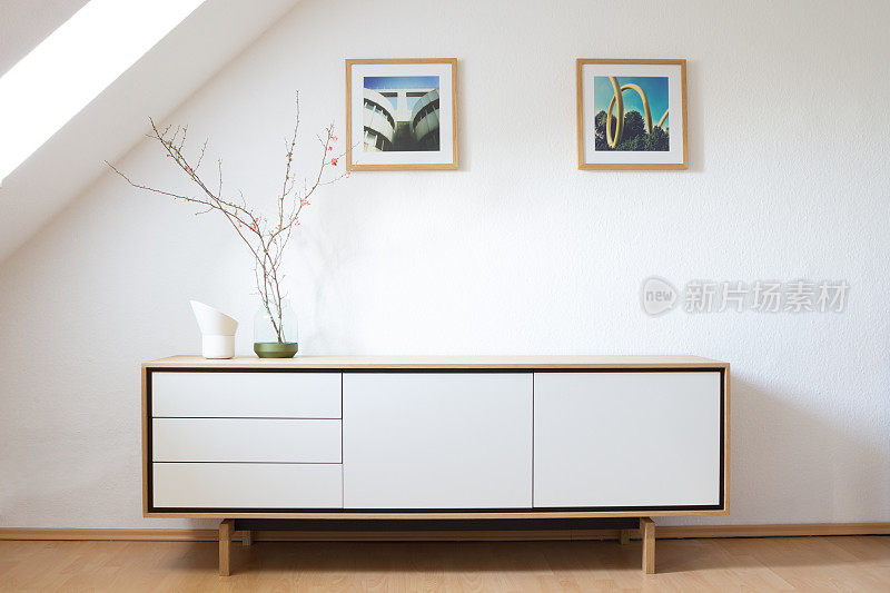 明亮客厅里的现代餐具柜。现代生活，室内设计。斯堪的纳维亚设计。