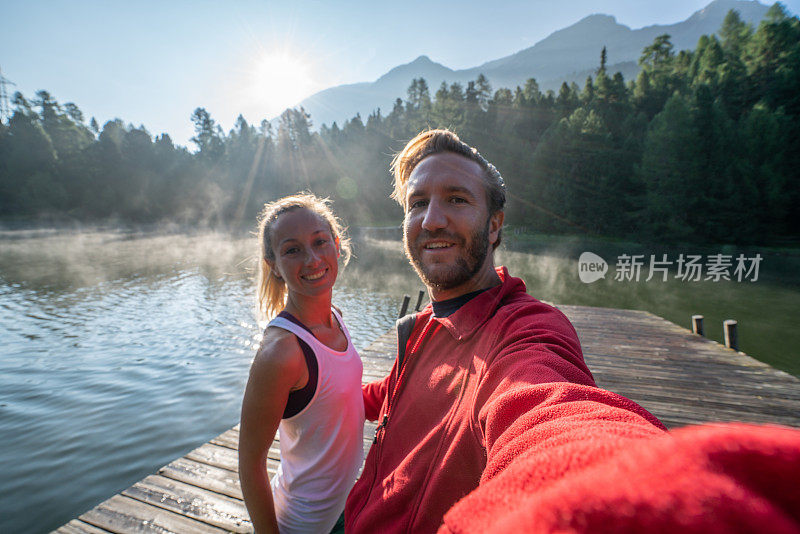 年轻夫妇的自拍照在湖码头在早晨的雾，瑞士