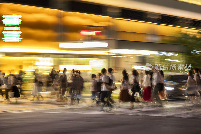 日本东京黄昏时穿过马路的人群