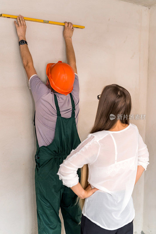 女人控制男人如何用水平仪测量墙壁