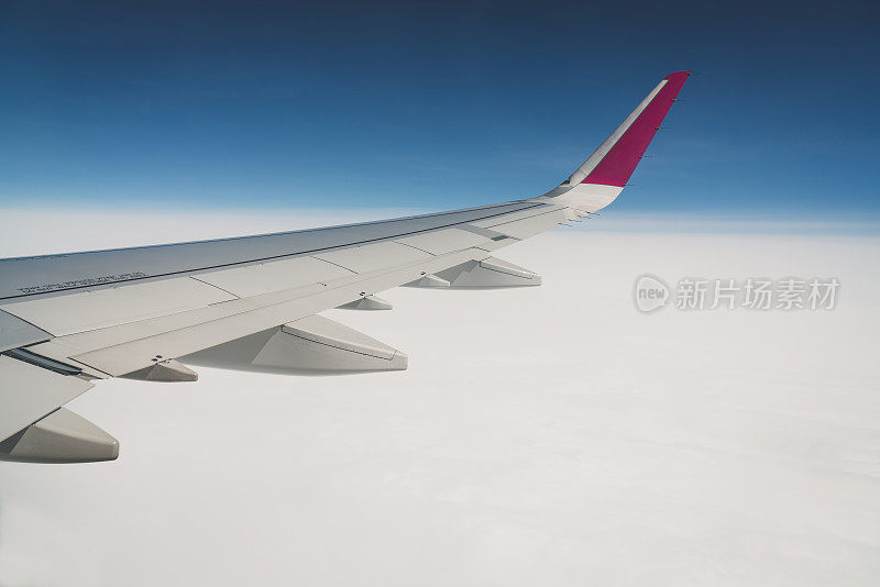 当飞机机翼在云层上飞行时