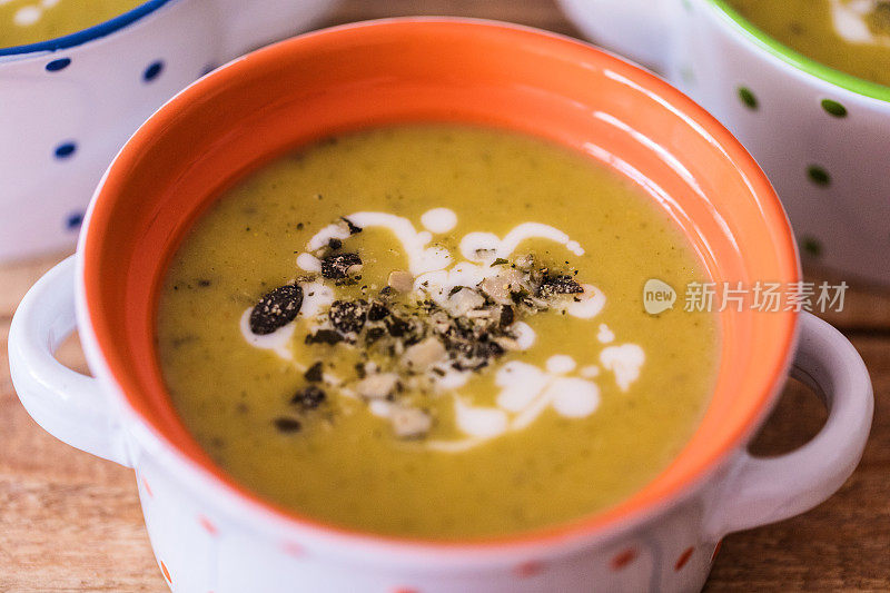 花椰菜汤加南瓜子，烤面包装在陶瓷碗中即食