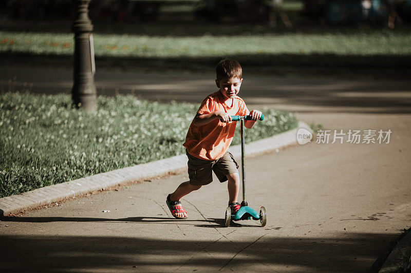 小男孩骑着滑板车
