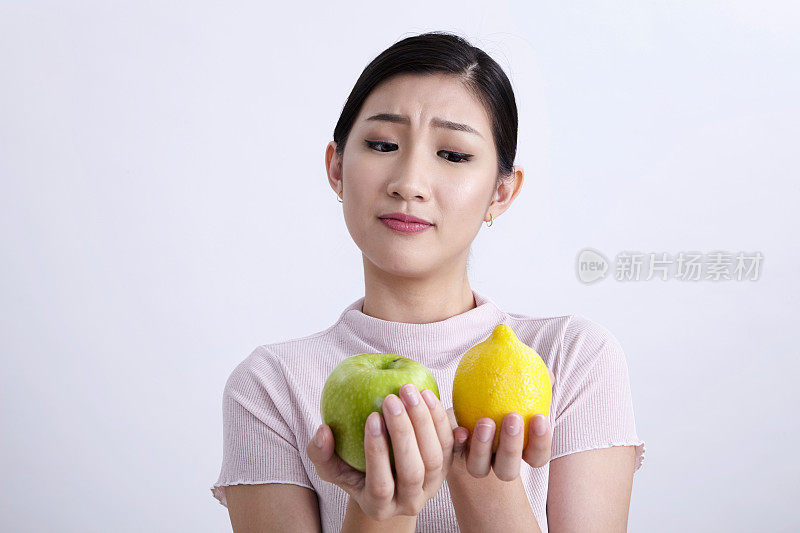 中国妇女拿着青苹果和柠檬