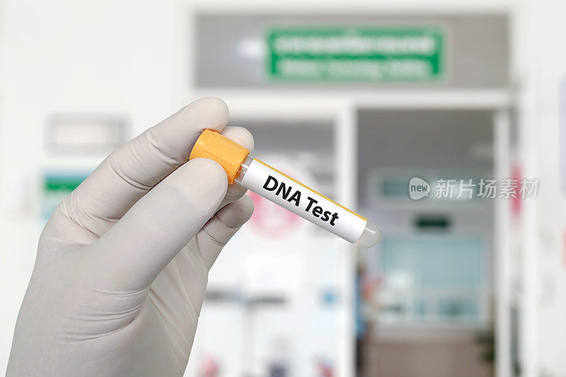 DNA测试。医生拿着血样采集管在实验室前做DNA检测。