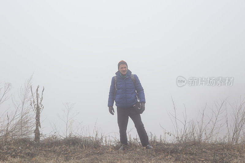 一名成年男子在寒冷多雾的日子徒步旅行